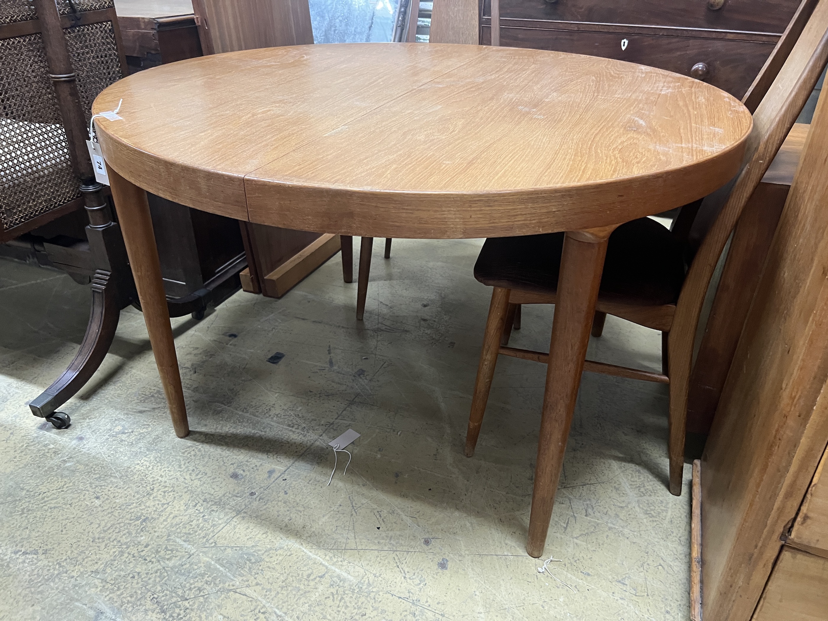 A mid century circular teak extending dining table, length 130cm extended, two spare leaves, depth 120cm, height 72cm
